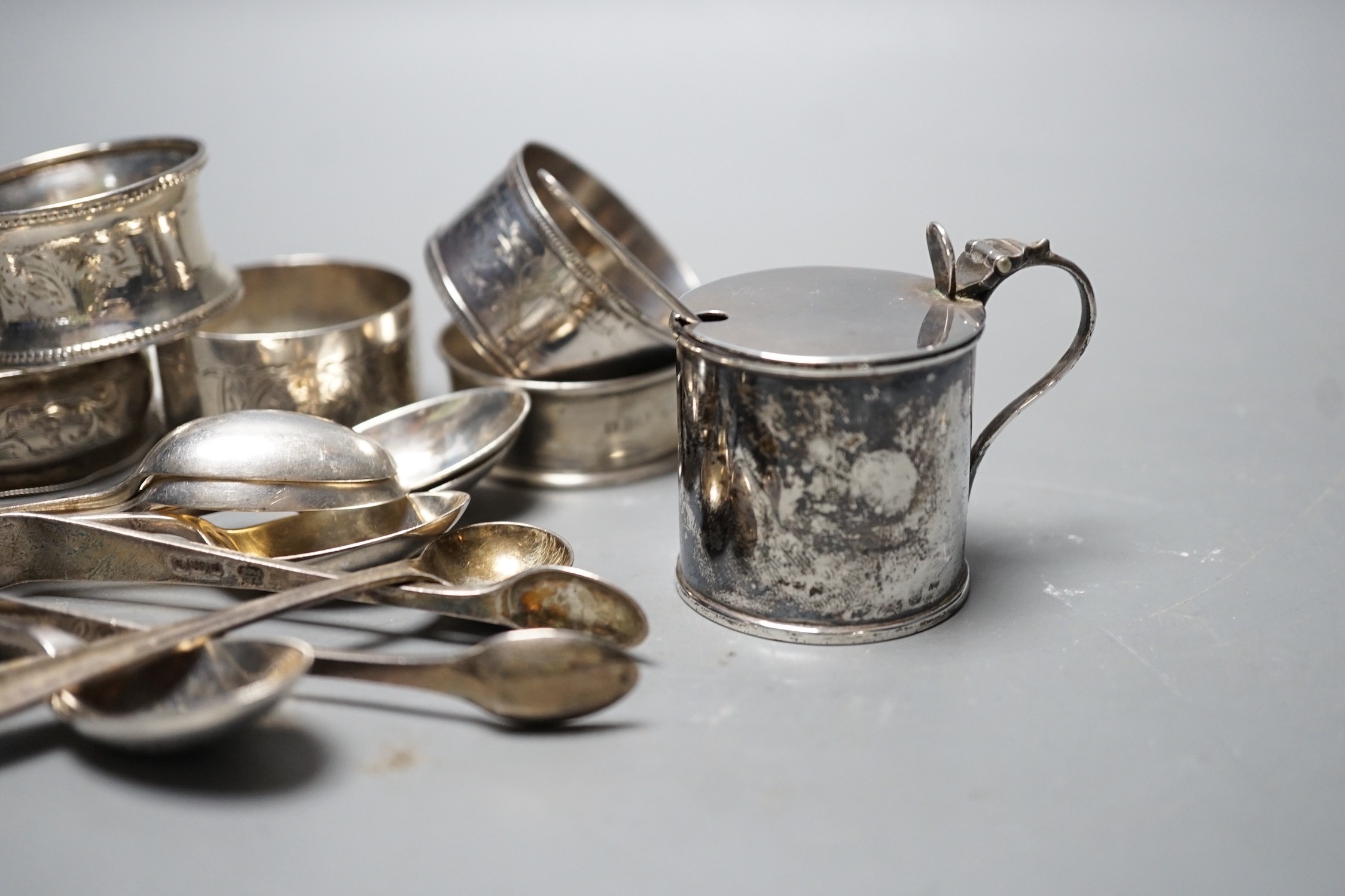 An Edwardian silver mustard pot, Birmingham, 1905, a set of six 'Onslow' pattern silver teaspoons by William Hutton & Sons, London, 1903, a pair of silver sugar tongs, a silver condiment spoons, six assorted silver napki